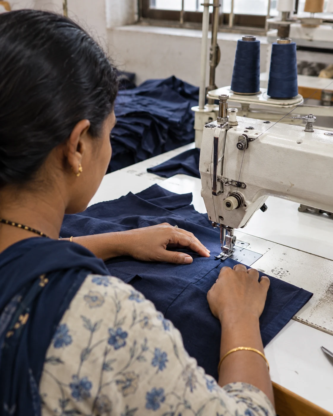 AI-generated illustrative view of a seamstress stitching navy cotton